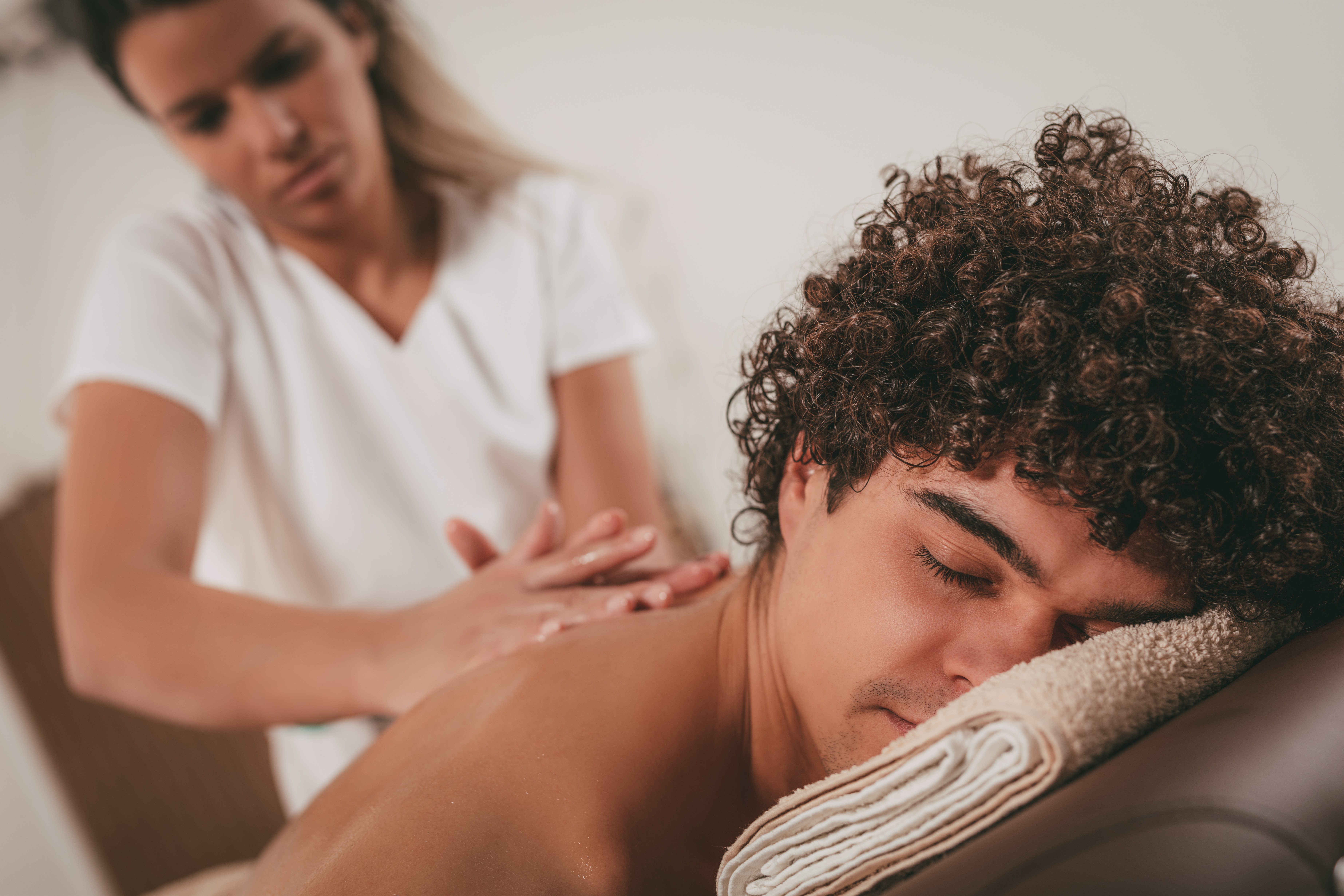 A  massage therapist gives a relaxing massage to a male client