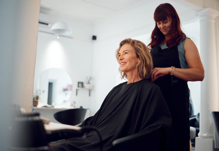 A hairdresser styling the hair of a happy customer. 