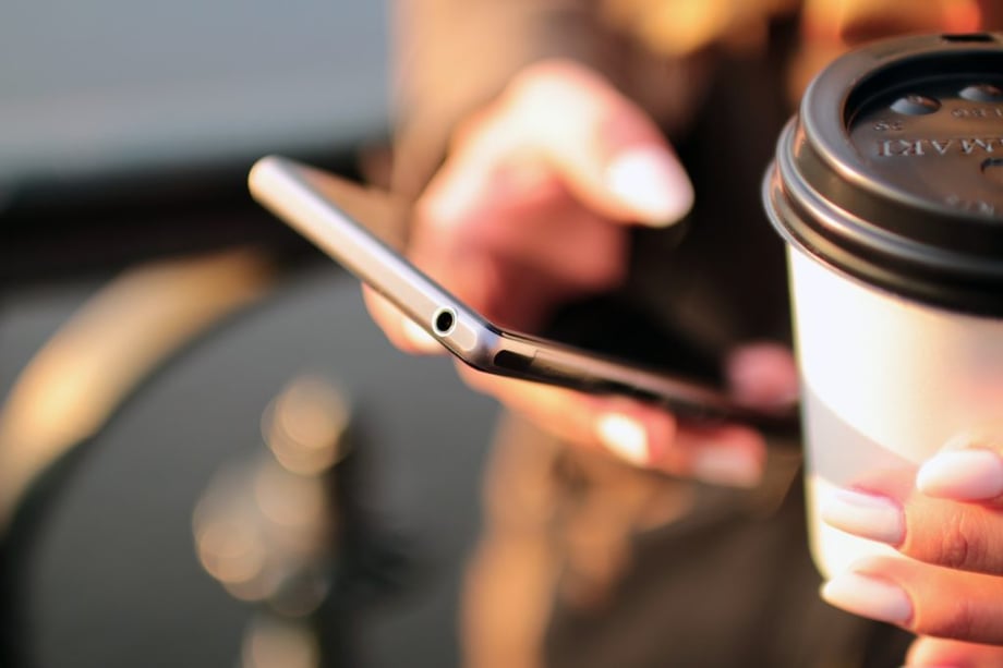 Woman holding phone and coffee