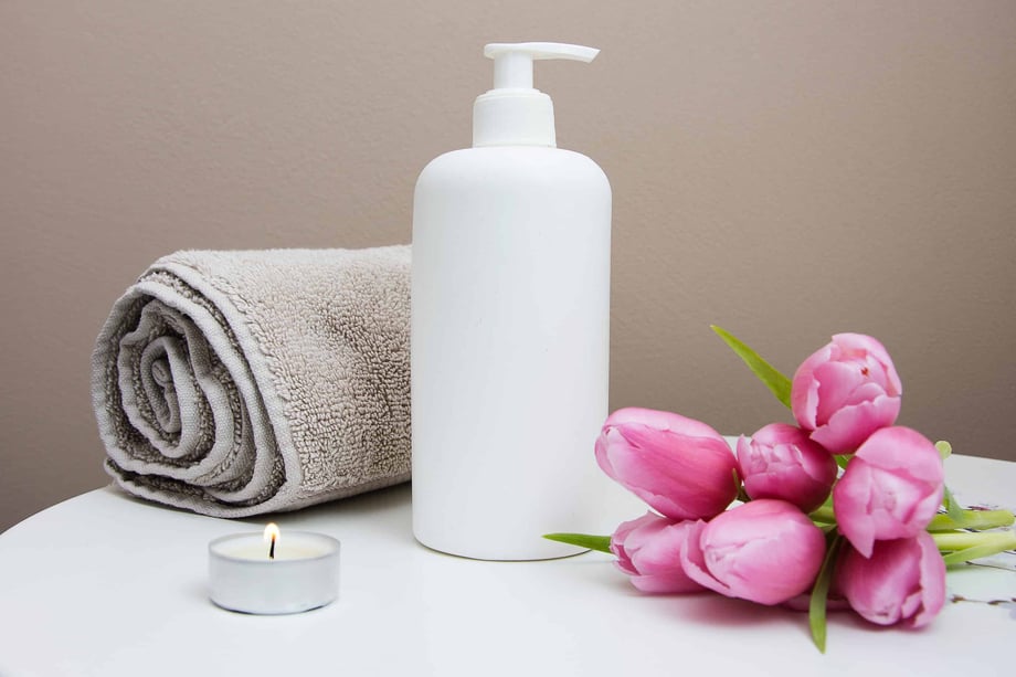 Towel, lotion, candle, and flowers