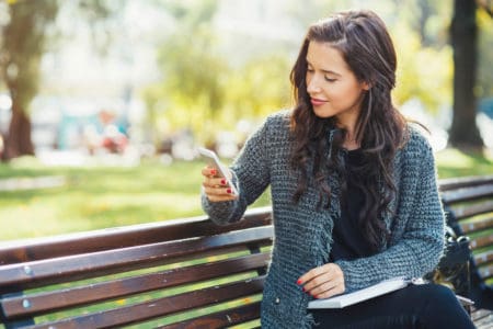 Woman on phone sitting on park bench