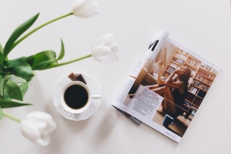 Flowers, cup of coffee, and magazine on table