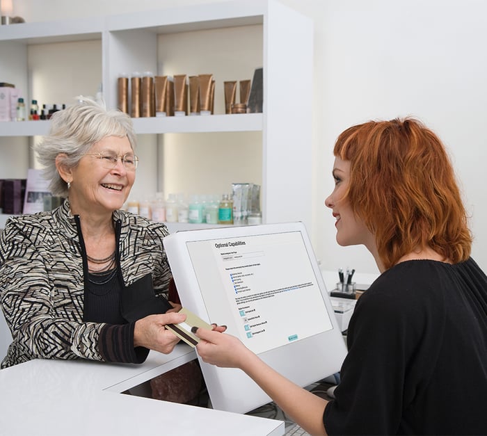 Salon receptionist checking out customer