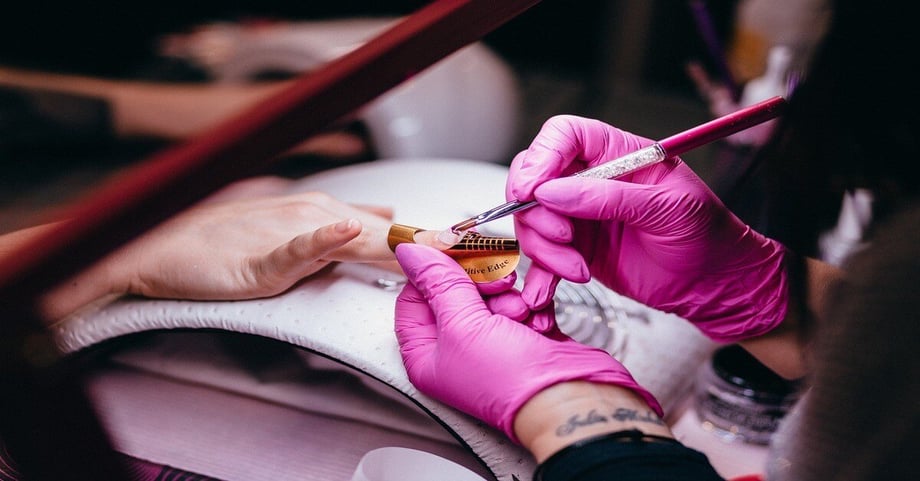 A nail tech does a client’s nails in a salon.