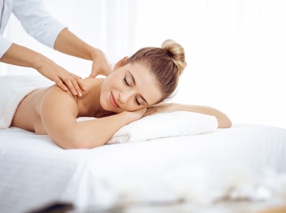 A young woman enjoys a back massage. 